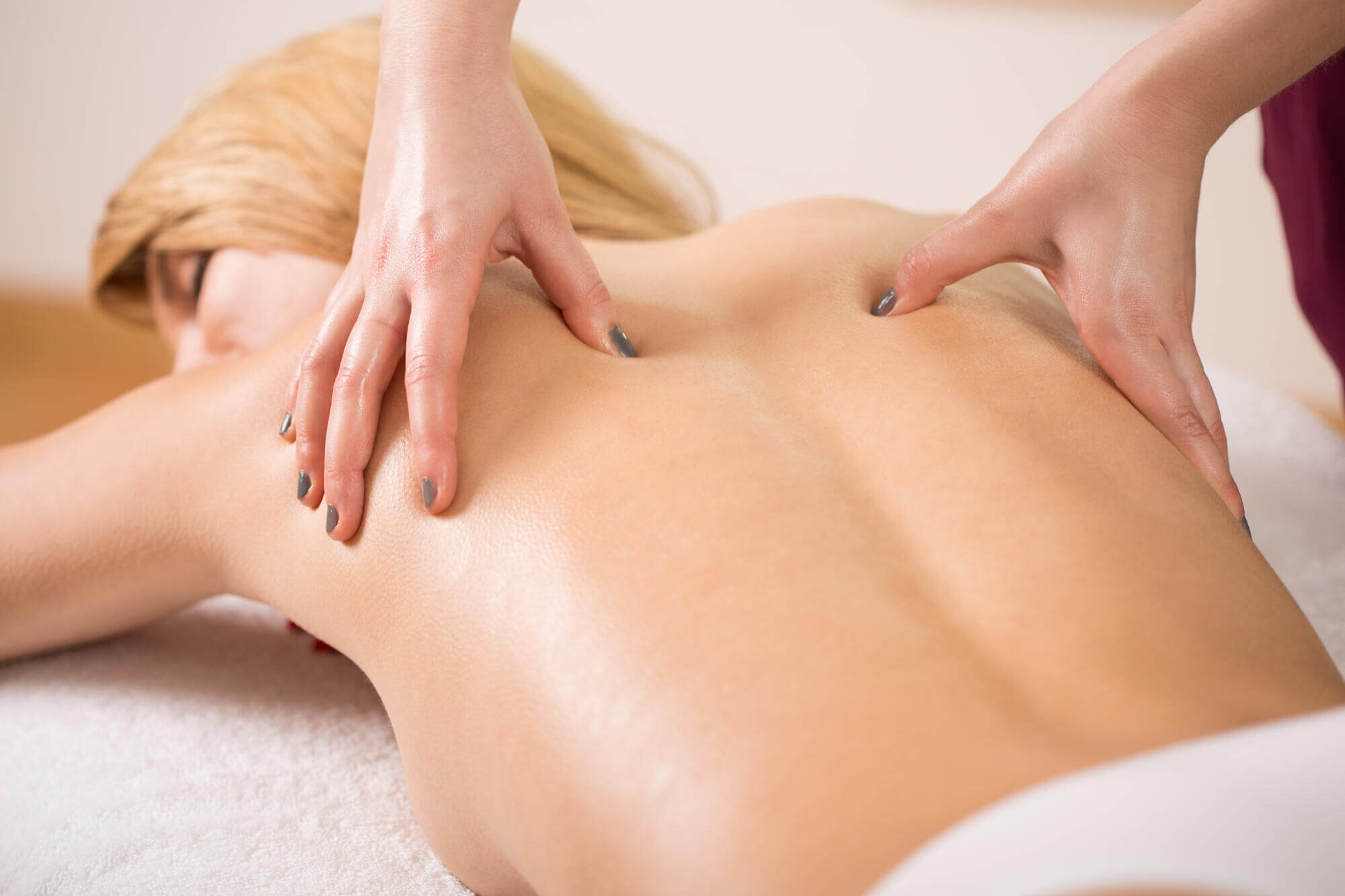 Therapist Pressing Tight Muscles On Woman's Back